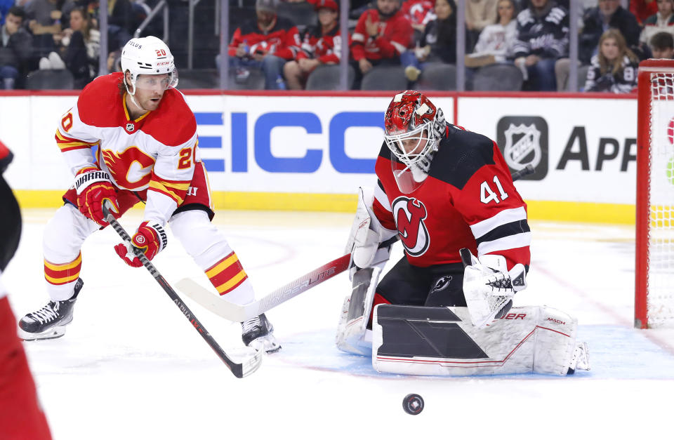 New Jersey Devils goaltender Vitek Vanecek (41) makes a save against Calgary Flames center Blake Coleman (20) during the second period of an NHL hockey game, Tuesday, Nov. 8, 2022, in Newark, N.J. (AP Photo/Noah K. Murray)