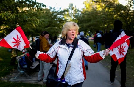 FILE PHOTO: A woman waves flags on the day Canada legalizes recreational marijuana at Trinity Bellwoods Park