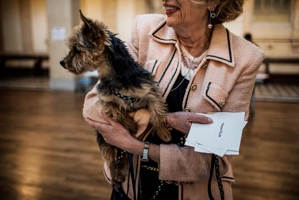 <p>A woman carries her dog as she cast her ballot at a polling station in Lyon, on April 23, 2017, during the first round of the Presidential elections. (Photo: Jeff Pachoud/AFP/Getty Images) </p>