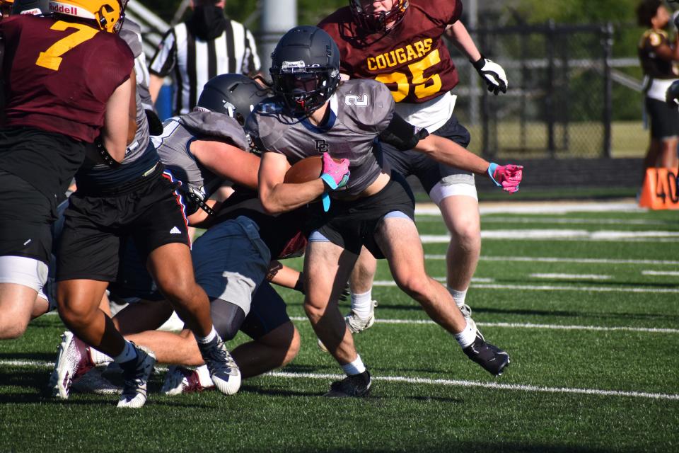Decatur Central's Presley Newkirk avoids a tackle by a Bloomington North defender during the Hawks' four-way scrimmage with the Cougars, Castle and Speedway on June 23, 2022.