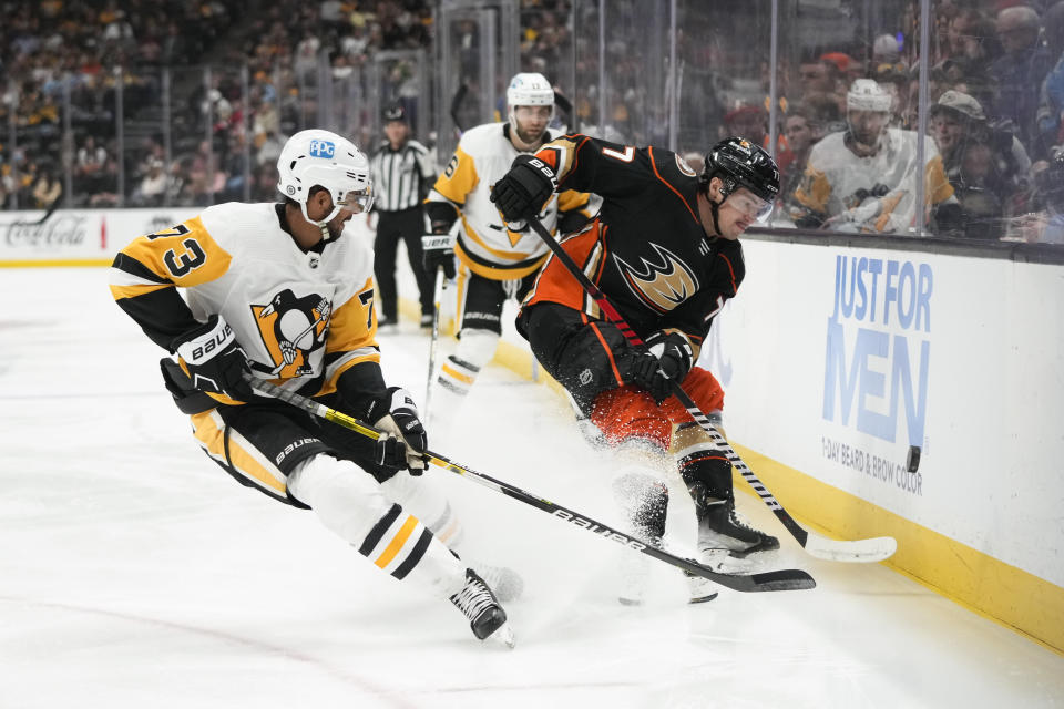 Anaheim Ducks' Frank Vatrano (77) hits the puck under defense by Pittsburgh Penguins' Pierre-Olivier Joseph (73) during the first period of an NHL hockey game Friday, Feb. 10, 2023, in Anaheim, Calif. (AP Photo/Jae C. Hong)