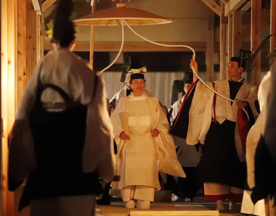 Japan's Emperor Naruhito, center, walks toward Yukiden, one of two main halls of the shrine for Daijosai, or great thanksgiving festival, at the Imperial Palace in Tokyo Thursday, Nov.  14, 2019. Naruhito performed a secretive and controversial ritual Thursday, a once-in-a-reign event to give thanks for good harvests, pray for the peace and safety of the nation and play host to his family’s ancestral gods. (Kyodo News via AP)