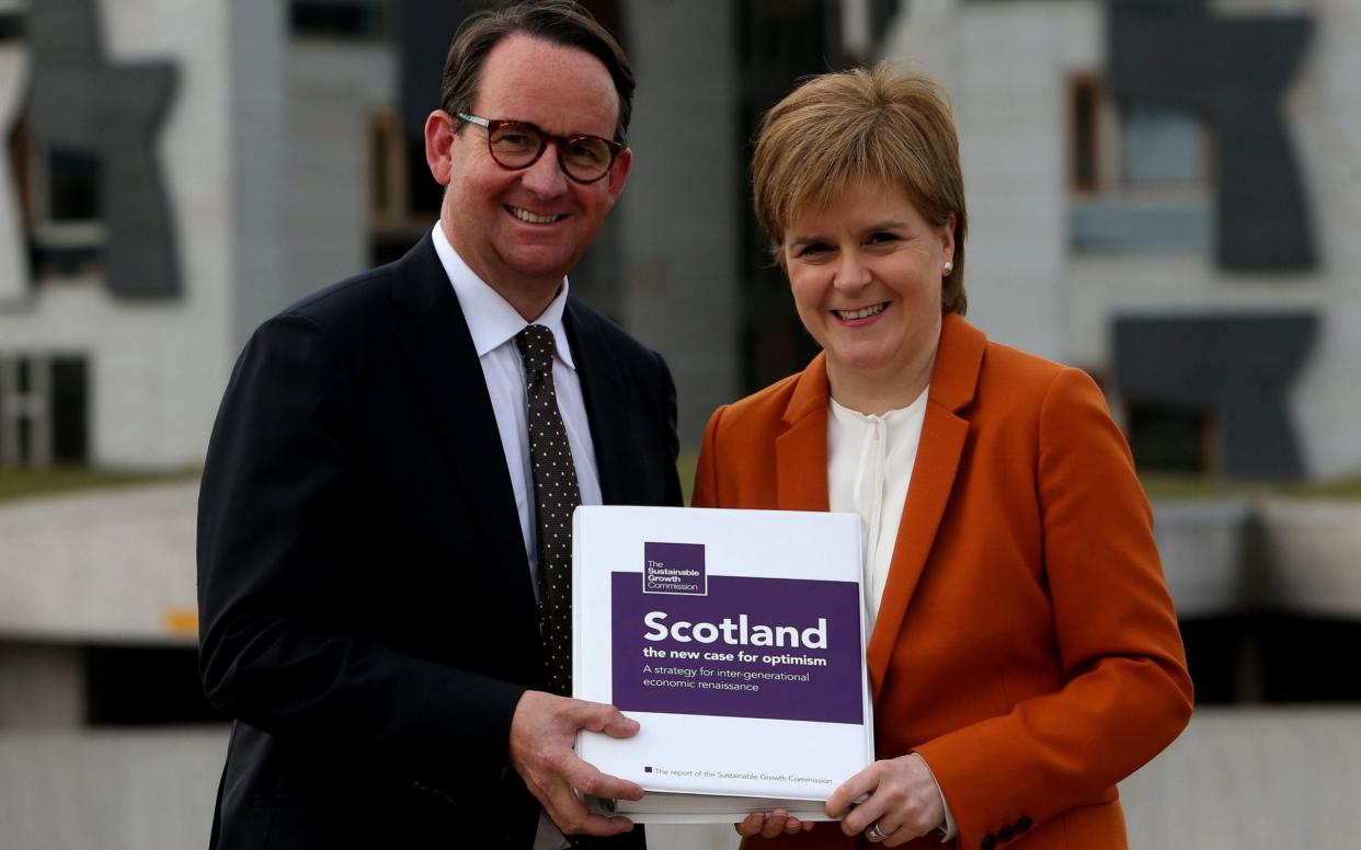 First Minister Nicola Sturgeon receives the Sustainable Growth Commission report from commission chair Andrew Wilson - PA