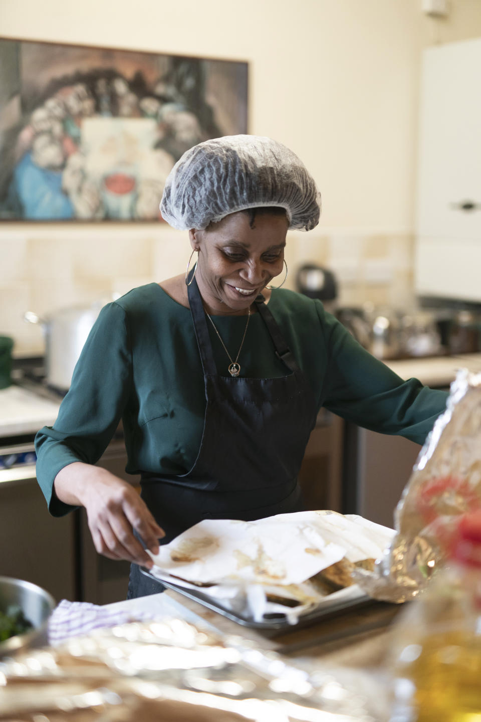 Chief coordinator Glenda Andrew prepares West Indian meals with members of the Preston Windrush Covid Response team, at the Xaverian Sanctuary, in Preston, England, Friday Feb. 19, 2021. Once a week, the team distribute meals to people in Preston and surrounding communities in northwestern England that have recorded some of the U.K.’s highest coronavirus infection rates. The meal program grew out of Andrew’s work with Preston Windrush Generation & Descendants, a group organized to fight for the rights of early immigrants from the Caribbean and other former British colonies who found themselves threatened with deportation in recent years. (AP Photo/Jon Super)