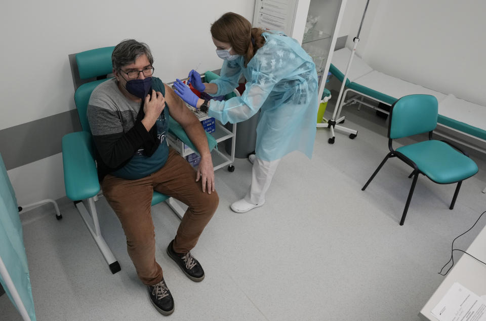 Andrzej Wiazecki, a 56-year-old resident of Warsaw receives a booster shot against COVID-19, in Warsaw, Poland, Tuesday Dec. 7, 2021. Poland and several other countries across central and eastern Europe are battling a massive surge of infection and death fueled by the transmissible delta variant. Now they face the specter of the another variant, omicron, with vaccinations rates far lower in the Western Europe. (AP Photo/Czarek Sokolowski)