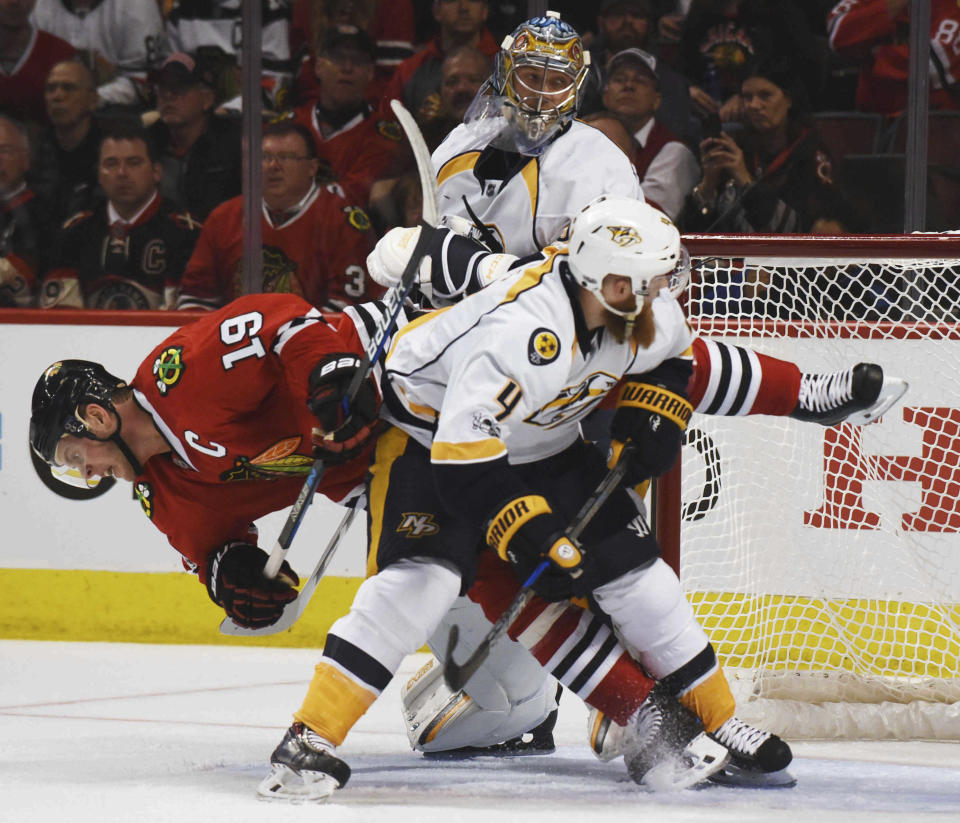 Chicago Blackhawks center Jonathan Toews falls to the ice after coming into contact with Nashville Predators defenseman Ryan Ellis during Game 1 of a first-round NHL hockey playoff series Thursday, April 13, 2017, in Chicago. (Joe Lewnard/Daily Herald via AP)