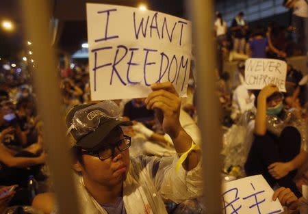 Protesters hold up signs during an evening rally attended by thousands in front of the government headquarters in Hong Kong September 27, 2014. REUTERS/Bobby Yip