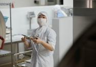 Nutritionist Kazumi Sato checks a meal for the school lunch inside the cookroom at Senju Aoba Junior High School in Tokyo