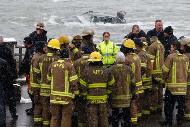 Emergency personnel gather at the edge of the river where a woman was removed from a submerged vehicle. (Photo: Jeffrey T. Barnes via AP)