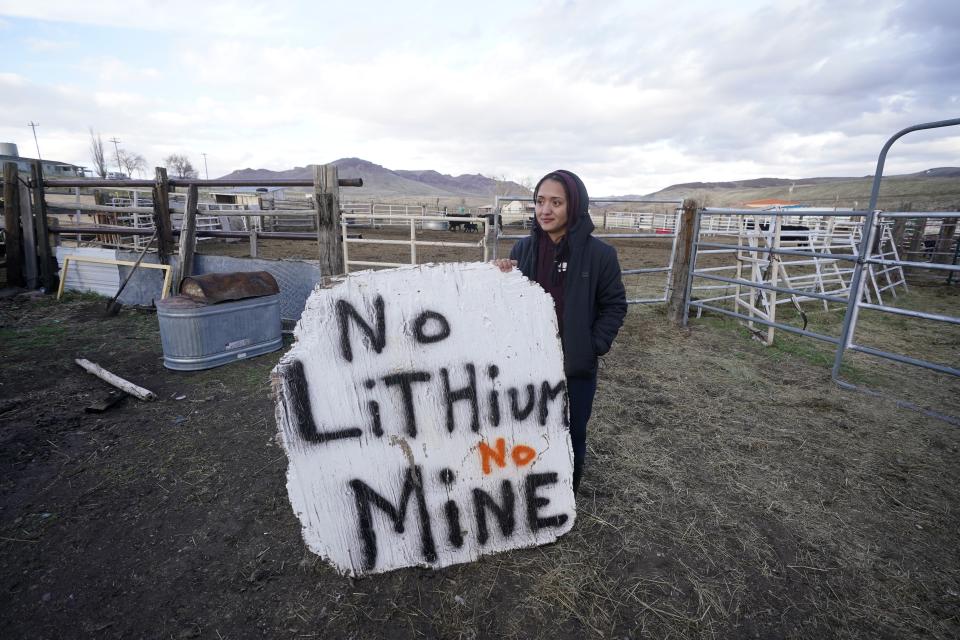 FILE - Daranda Hinkey, a Fort McDermitt Paiute and Shoshone tribe member, holds a large hand-painted sign that says "No Lithium No mine" at her home, on April 24, 2023, on the Fort McDermitt Indian Reservation, near McDermitt, Nev. U.S. Bureau of Land Management has been fighting mining challenges for nearly three years of all sorts, like those of environmentalists, tribal leaders, ranchers and others who want to overturn its approval of a huge lithium mine in the works in northwest Nevada near the Oregon line. (AP Photo/Rick Bowmer, File)
