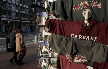 People walk past Harvard University t-shirts for sale in Harvard Square in Cambridge, Massachusetts in this November 16, 2012 file photo. REUTERS/Jessica Rinaldi/Files