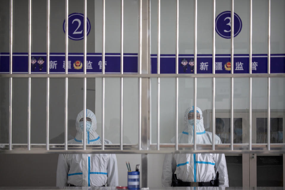 Security officers in protective suits stand at a reception area at the visitors' hall at the Urumqi No. 3 Detention Center in Dabancheng in western China's Xinjiang Uyghur Autonomous Region, on April 23, 2021. Urumqi No. 3, China's largest detention center, is twice the size of Vatican City and has room for at least 10,000 inmates. (AP Photo/Mark Schiefelbein)