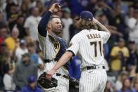 Milwaukee Brewers' Josh Hader and Manny Pina celebrate after a baseball game against the Chicago Cubs Saturday, Sept. 18, 2021, in Milwaukee. The Brewers won 6-4 and clinched a spot in the 2021 Postseason. (AP Photo/Morry Gash)