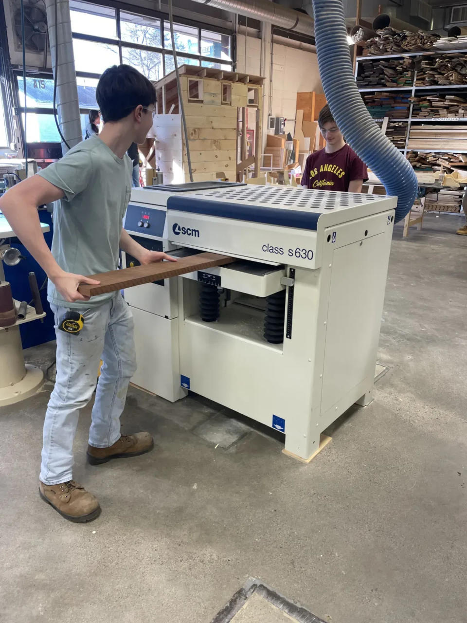 B-P junior carpentry student Casey Williams, left, feeds a board through a planer to Justin Deangelis. The pair helped build a podium for the Dighton Police Department.