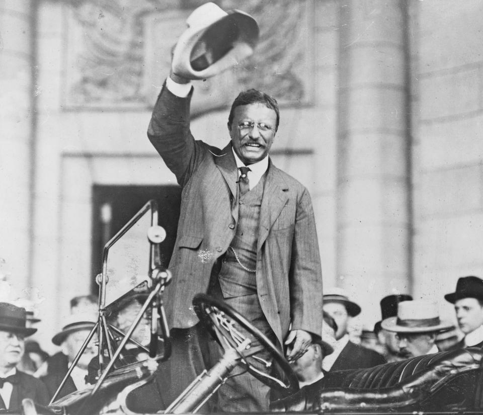 Theodore Roosevelt waves his hat