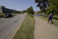 A woman walks on a trail adjacent to Volker Road Thursday, Sept. 24, 2020, in Kansas City, Mo. The stretch of road, along with parts of two other streets, would be renamed to honor Rev. Martin Luther King Jr. under a city proposal coming in the wake of failed effort to honor King last year. (AP Photo/Charlie Riedel)