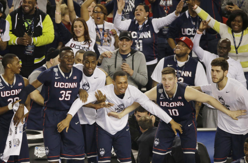 Connecticut players and fans begin to celebrate in the final moments of the team's 63-53 victory over Florida at their NCAA Final Four tournament college basketball semifinal game Saturday, April 5, 2014, in Arlington, Texas. (AP Photo/Tony Gutierrez)