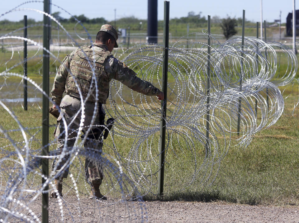 Members of the military police close a barbed wire entrance to Base Camp Donna as U.S. Secretary of Defense James Mattis visits on Wednesday, Nov. 14, 2018, in Donna, Texas. (Joel Martinez/The Monitor via AP)