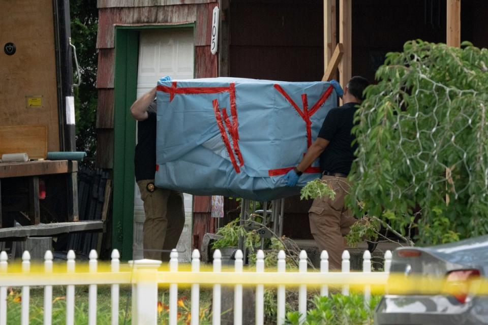 New York State police officers carry out a large item from the home of Rex Heuermann (AP)