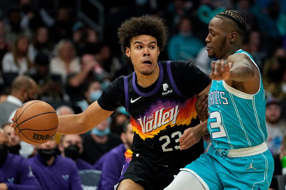 Phoenix Suns forward Cameron Johnson drives to the basket past Charlotte Hornets guard Terry Rozier during the first half of an NBA basketball game on Sunday, Jan. 2, 2022, in Charlotte, N.C.