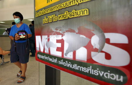 A woman wearing a mask walks past an information banner on Middle East Respiratory Syndrome (MERS) at the entrance of Bamrasnaradura Infectious Diseases Institute in Nonthaburi province, on the outskirts of Bangkok, Thailand, June 19, 2015. REUTERS/Chaiwat Subprasom