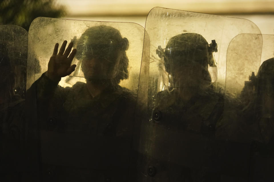 Law enforcement in riot gear line up against protesters during clashes outside the Kenosha County Courthouse late Tuesday, Aug. 25, 2020, in Kenosha, Wis. Protests continue following the police shooting of Jacob Blake two days earlier. (AP Photo/David Goldman)