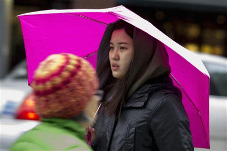 A woman walks carrying an umbrella through Union Square in New York November 26, 2013. REUTERS/Brendan McDermid