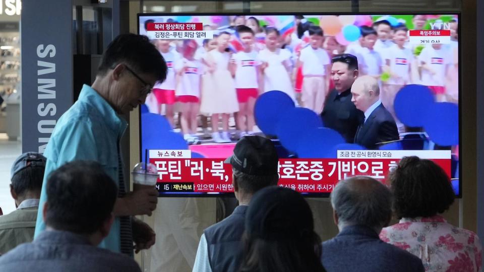 A TV screen in Seoul shows Vladimir Putin and Kim Jong-un