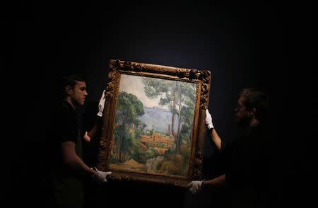 Art handlers pose with "Vue sur l'Estaque et le Chateau d'If" by Paul Cezanne at Christie's auction house in London, January 30, 2015. REUTERS/Suzanne Plunkett