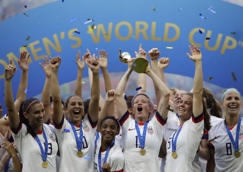 FILE - In this July 7, 2019, file photo, United States' Megan Rapinoe lifts up a trophy after winning the Women's World Cup final soccer match between U.S. and The Netherlands at the Stade de Lyon in Decines, outside Lyon, France. "We've done exactly what we set out to do, done exactly what we wanted to do, said what we feel," said Rapinoe. "I know sometimes my voice is louder, but everybody is in this together." (AP Photo/Alessandra Tarantino, File)
