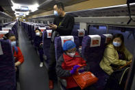 Passengers wearing face masks to protect against the spread of new coronavirus board the first high-speed train to leave Hankou train station after the resumption of train services in Wuhan in central China's Hubei Province, Wednesday, April 8, 2020. After 11 weeks of lockdown, the first train departed Wednesday morning from a re-opened Wuhan, the origin point for the coronavirus pandemic, as residents once again were allowed to travel in and out of the sprawling central Chinese city. (AP Photo/Ng Han Guan)