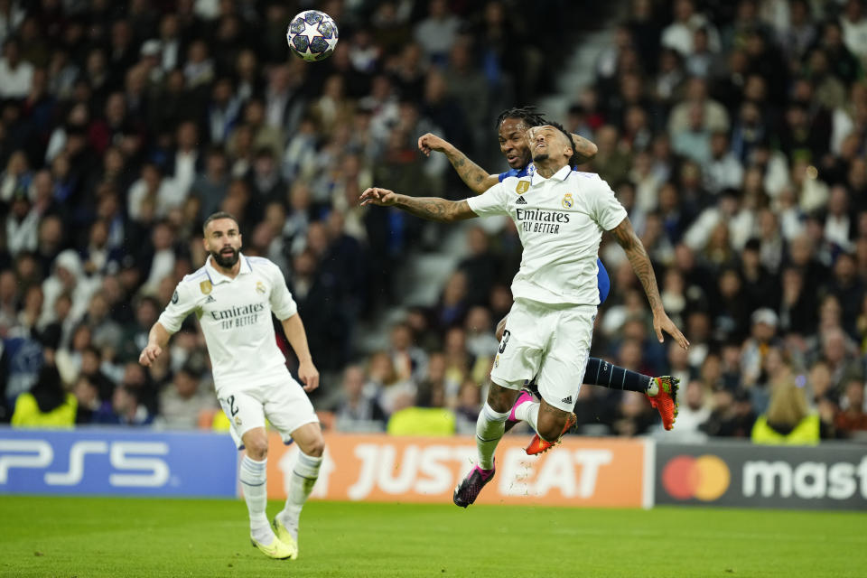 Real Madrid's Eder Militao, right, goes for a header with Chelsea's Raheem Sterling during the Champions League quarter final first leg soccer match between Real Madrid and Chelsea at Santiago Bernabeu stadium in Madrid, Wednesday, April 12, 2023. (AP Photo/Jose Breton)