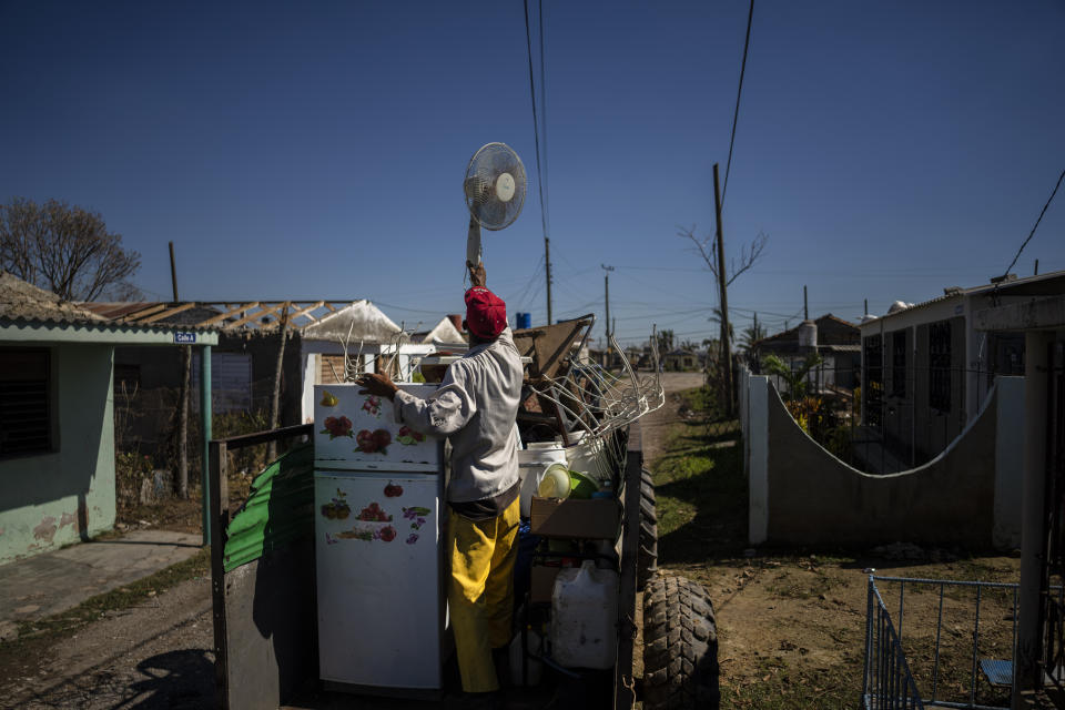 A man helps load a trailer with the belongings of his friends, who are moving the items to a home in better conditions, one week after Hurricane Ian in La Coloma, Pinar del Rio province, Cuba, Wednesday, Oct. 5, 2022. (AP Photo/Ramon Espinosa)