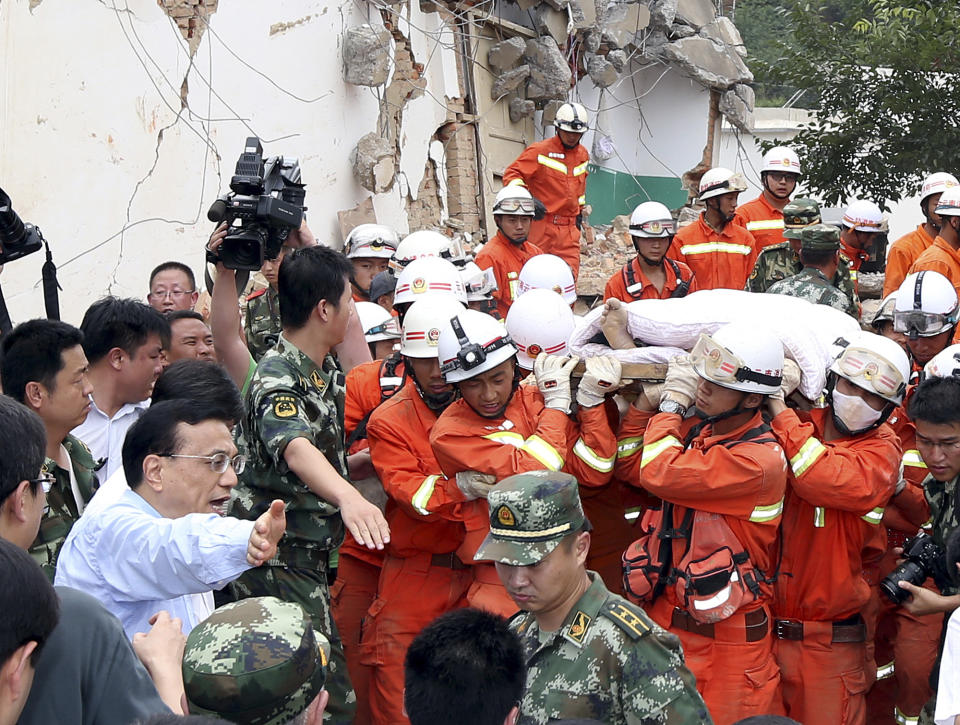 FILE - In this photo released by China's Xinhua News Agency, Chinese Premier Li Keqiang helps make way for the injured at the earthquake zone in the town of Longtoushan in Ludian County in southwest China's Yunnan Province, Aug. 4, 2014. For most of his career, Li was known as a cautious, capable, and highly intelligent bureaucrat who rose through, and was bound by, a consensus-oriented Communist Party that reflexively stifles dissent. (Yao DaweiXinhua via AP, File)