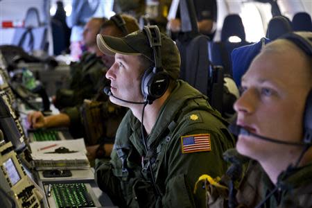 Lieutenant Commander Mike Trumbull, a Naval Flight Officer assigned to Patrol Squadron (VP) 16, monitors his workstation on a P-8A Poseidon during a mission to assist in search and rescue operations for Malaysia Airlines flight MH370 in this March 24, 2014 handout photo. REUTERS/Mass Communication Specialist 2nd Class Eric A. Pastor/U.S. Navy/Handout via Reuters