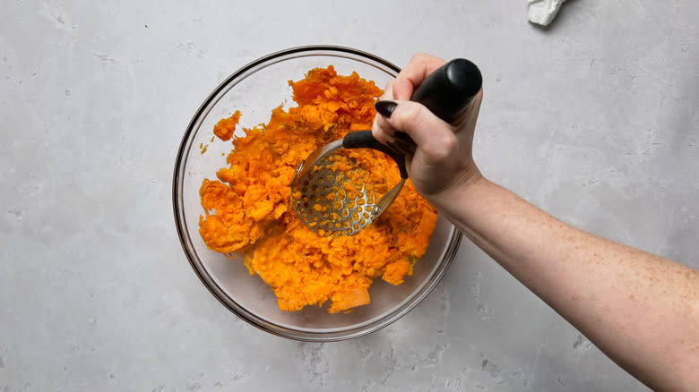 mashing carrots in bowl