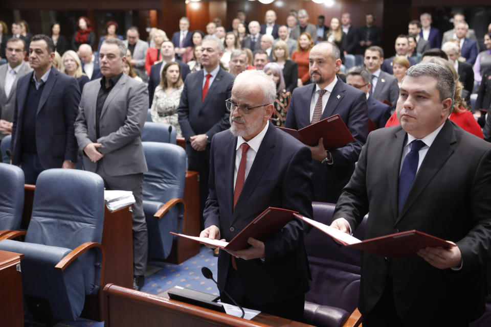 Talat Xhaferi, center front, the new prime minister of the caretaker government, takes an oath with the members of the cabinet in Skopje, North Macedonia, on Sunday, Jan. 28, 2024, after the parliament voted in favor for a new caretaker government to be installed ahead of general elections this May. (AP Photo/Boris Grdanoski)