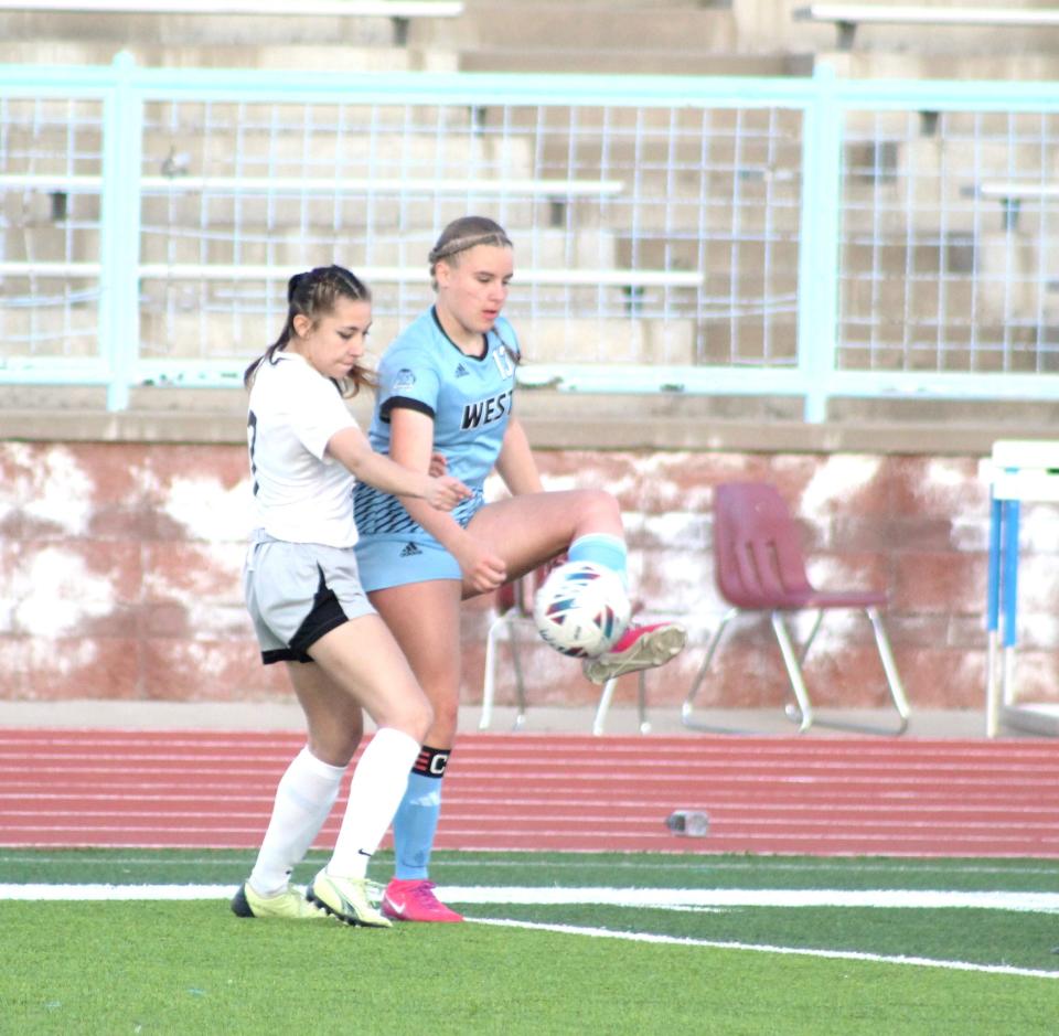 Pueblo West's Jocelyn Thompson settles down a cross field pass against Pueblo South's Aris Sena in a matchup between the two schools at Pueblo West High School on April 4, 2024.