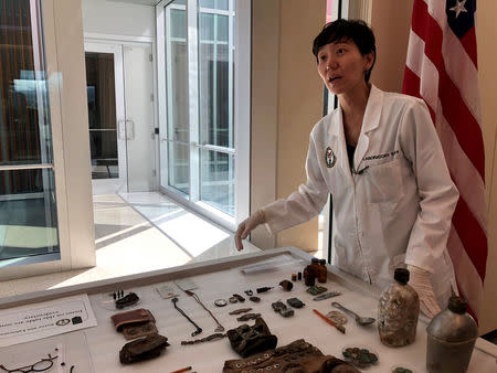 FILE PHOTO: Jennie Jin, a forensic anthropologist who leads the Korea War Project at the Defense POW/MIA Accounting Agency (DPAA), shows some of the objects that accompanied the human remains handed over by North Korea, including a wallet, buttons and canteens, at Joint Base Pearl Harbor-Hickam, Hawaii Sept. 10, 2018. REUTERS/Phil Stewart/File Photo