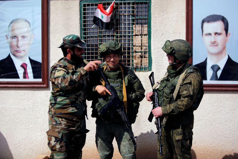 FILE PHOTO: Syrian and Russian soldiers are seen at a checkpoint near Wafideen camp in Damascus