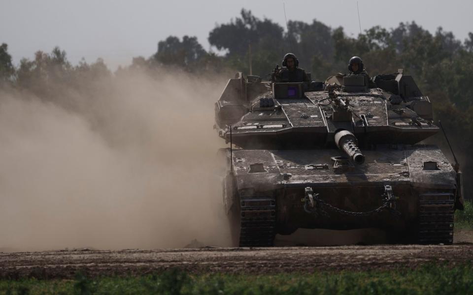 Israeli troops move a tank into position near the Israel-Gaza border on Tuesday, Jan 23