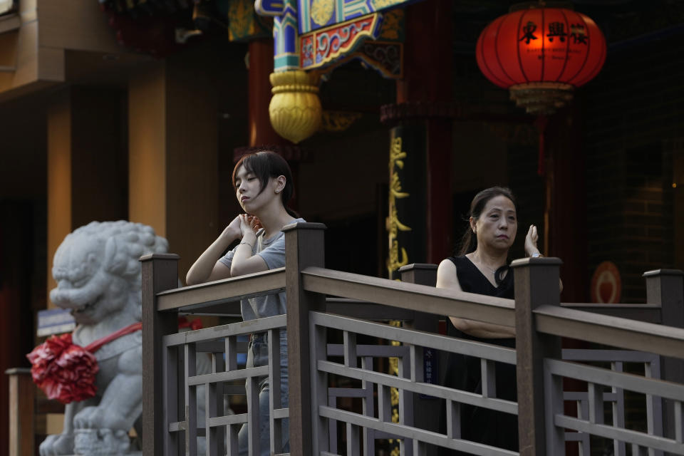 People wait outside a restaurant in Beijing, Tuesday, Aug. 15, 2023. Chinese leader Xi Jinping has called for patience in a speech released as the ruling Communist Party tries to reverse a deepening economic slump and said Western countries are "increasingly in trouble" because of their materialism and "spiritual poverty." (AP Photo/Ng Han Guan)