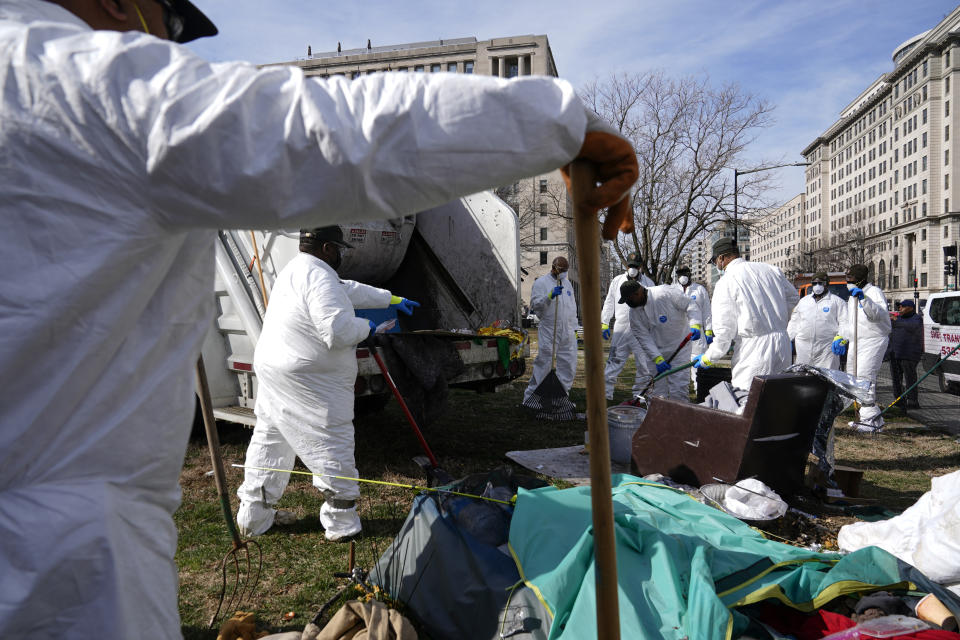 Workers clear a homeless encampment at McPherson Square in Washington, Wednesday, Feb. 15, 2023. (AP Photo/Patrick Semansky)