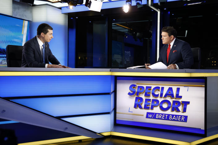 U.S. Secretary of Transportation Pete Buttigieg challenges Bret Baier, who leans forward aggressively, over a panel that says: Special Report w/ Brett Baier.. 