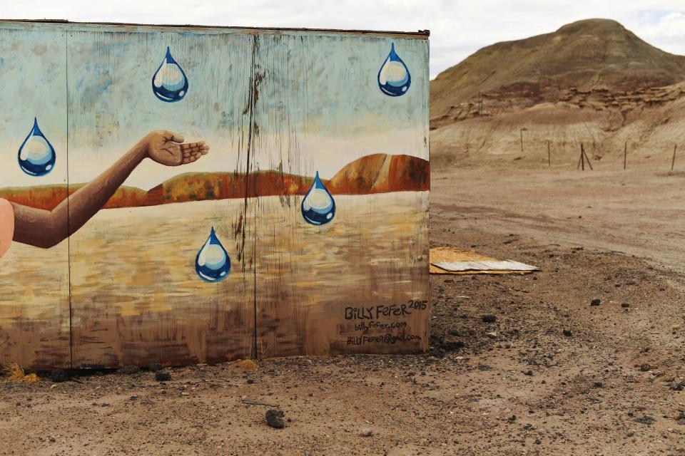 Artist Billy Fefer painted a mural on the side of a roadside stand where locals sell items on the Navajo Reservation near Cameron, Arizona. In the mural, a young child reaches out to touch a falling rain drop. Most of Navajo Nation has lived with drought for the past few decades. | Denver Post via Getty Images