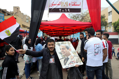 A man carries a portrait of Egyptian President Abdel Fattah al-Sisi outside a polling station, during the referendum on draft constitutional amendments, in Cairo, Egypt April 20, 2019. REUTERS/Mohamed Abd El Ghany