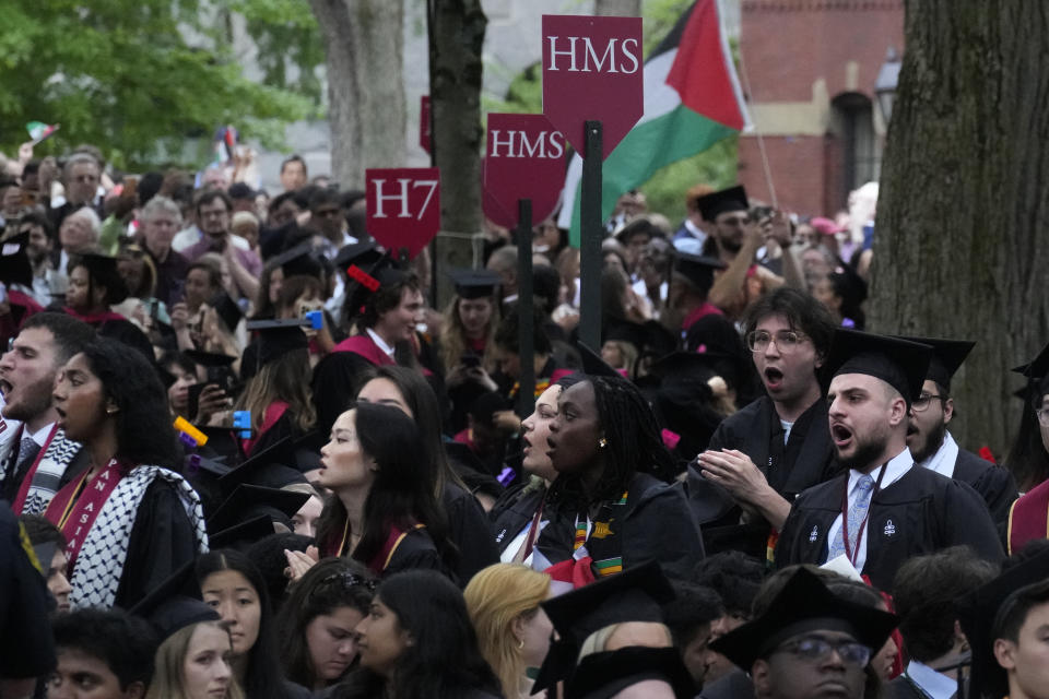 Graduating students chant as they depart commencement in protest to the 13 graduating seniors who were not allowed to participate due to protest activities, in Harvard Yard during commencement at Harvard University, Thursday, May 23, 2024, in Cambridge, Mass. (AP Photo/Charles Krupa)