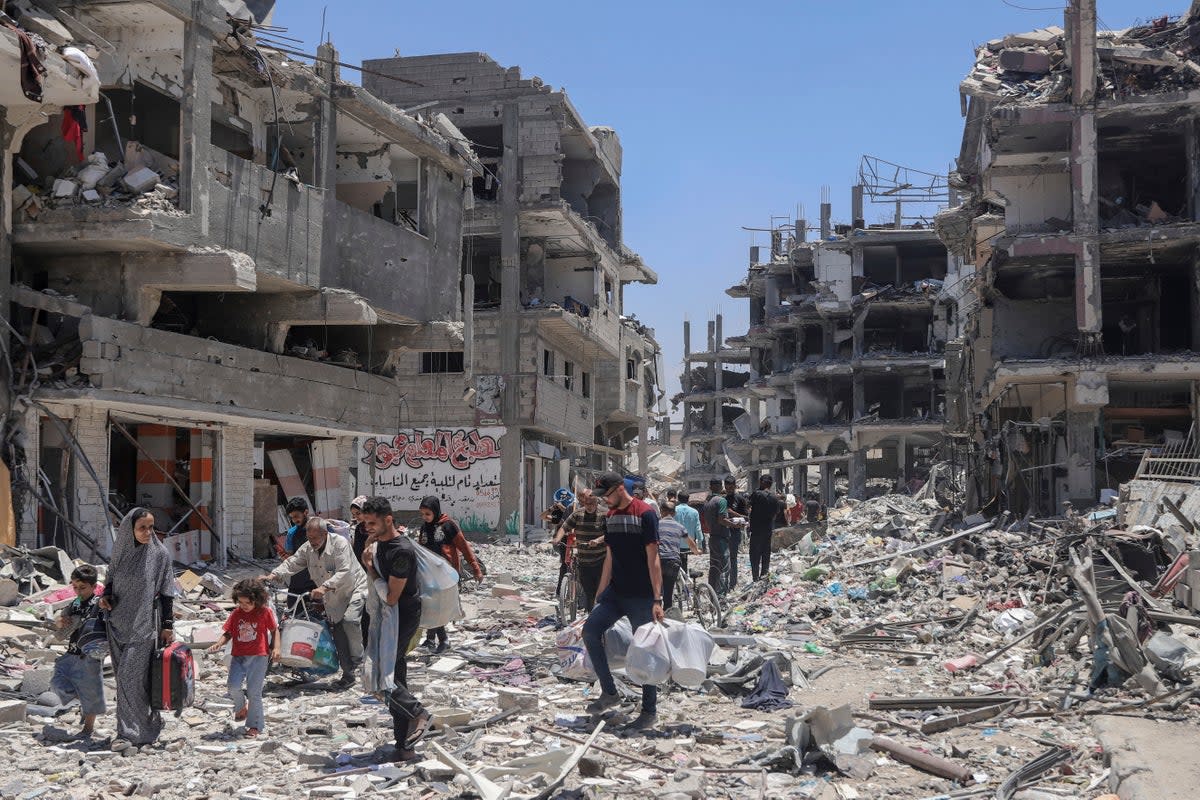 Palestinians walk through the destruction in the wake of an Israeli air and ground offensive in Jebaliya, northern Gaza Strip, (AP)