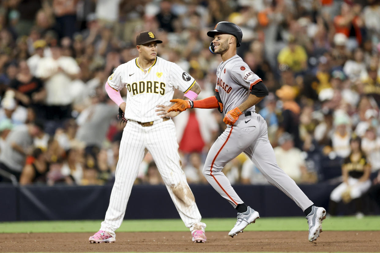 San Francisco Giants' Grant McCray, right, celebrates next to San Diego Padres third baseman Manny Machado, left, after hitting a two-run home run during the ninth inning of a baseball game Saturday, Sept. 7, 2024, in San Diego. (AP Photo/Ryan Sun)