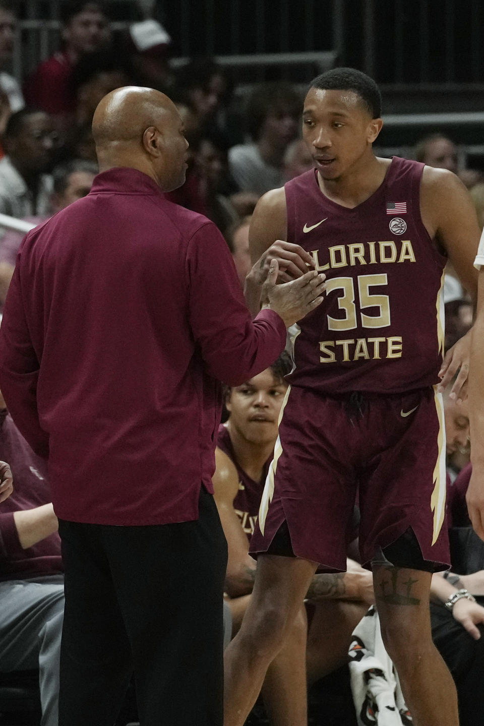 Florida State head coach Leonard Hamilton talks to Florida State guard Matthew Cleveland (35) during the second half of an NCAA college basketball game against Miami, Saturday, Feb. 25, 2023, in Coral Gables, Fla. (AP Photo/Marta Lavandier)